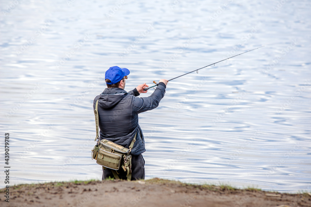 A man catches a fish on a spinning rod A man catches a fish on a spinning rod