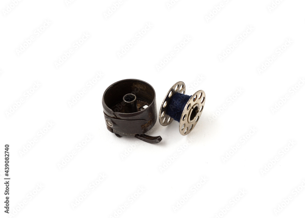 Sewing machine bobbin and bobbin case isolated on white background. Sewing machine bobbin and bobbin case isolated on white background.