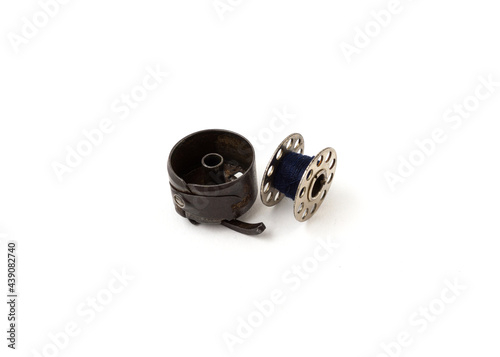 фотографія Sewing machine bobbin and bobbin case isolated on white background