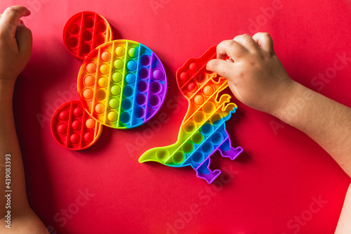 A child plays with a flapping fidget. popular children s flexible sensory toy develops fine motor skills  anti-stress  can be used for training with autistic people  popit toy