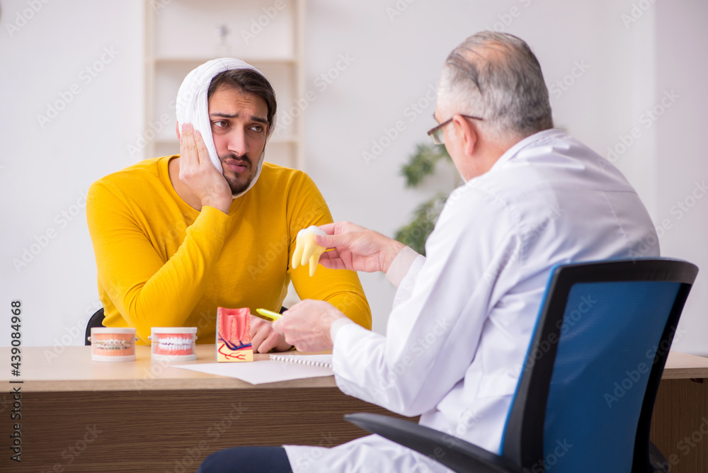 Fototapeta premium Young man visiting experienced male dentist