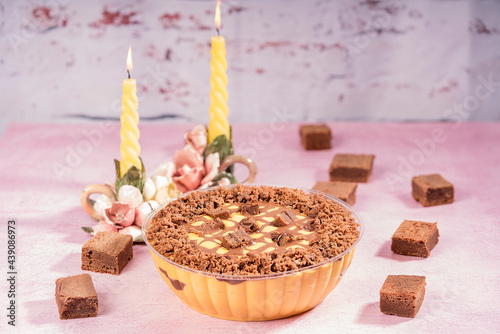 Delicious lucuma mousse with chocolate brownies, presented on a table with two candelabras. photo