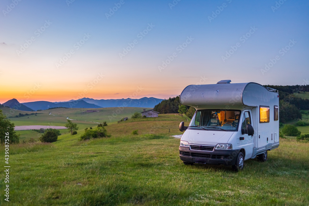 Sunset clear sky over camper van in Montelago highlands, Marche, Italy. Traveling road trip in unique hills and mountains landscape, alternative vanlife vacation concept. Sunset clear sky over camper van in Montelago highlands, Marche, Italy. Traveling road trip in unique hills and mountains landscape, alternative vanlife vacation concept.