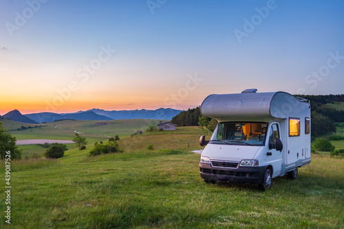 Sunset clear sky over camper van in Montelago highlands  Marche  Italy. Traveling road trip in unique hills and mountains landscape  alternative vanlife vacation concept.