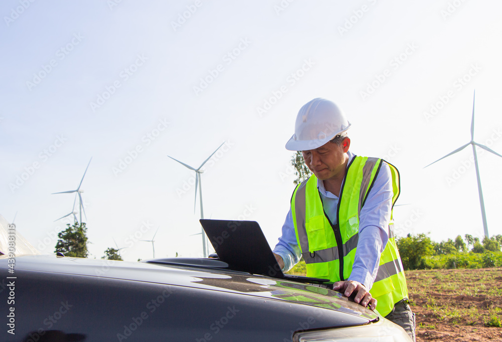 rear view man engineer wearing Personal protective equipment working in wind turbine farm background copy space rear view man engineer wearing Personal protective equipment working in wind turbine farm background copy space