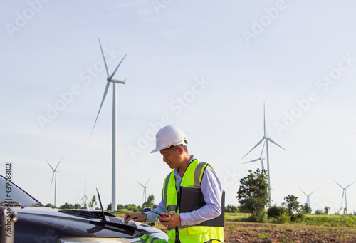 rear view man engineer wearing Personal protective equipment working in wind turbine farm background copy space