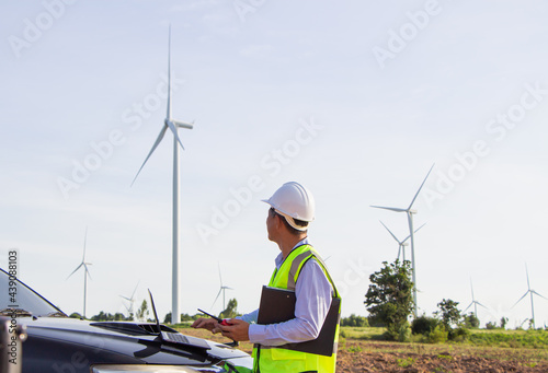 rear view man engineer wearing Personal protective equipment working in wind turbine farm background copy space