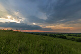 Evening landscape with meadow grasses and clouds above the horizon.