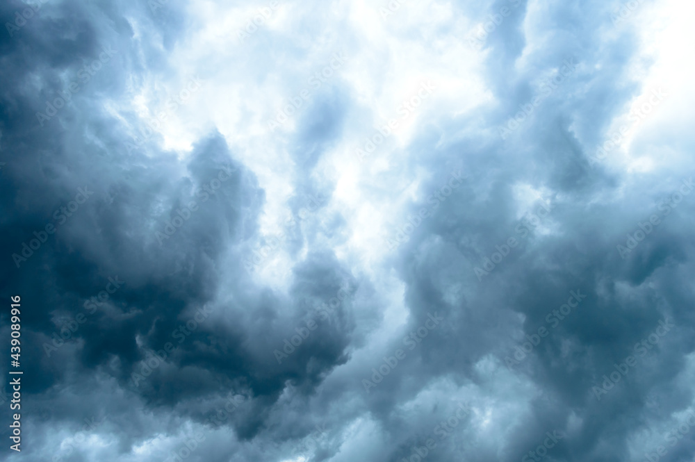 Thick dark black storm clouds covering summer sunset sky with gale-speed wind blowing just before Nor'westers Kalbaishakhi Bordoisila thunderstorm torrential rain. Atmospheric Texture background. Thick dark black storm clouds covering summer sunset sky with gale-speed wind blowing just before Nor'westers Kalbaishakhi Bordoisila thunderstorm torrential rain. Atmospheric Texture background.