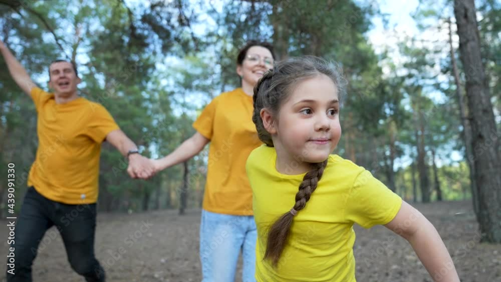 Happy family in park. Daughter and her parents are run in park. Hiking with family. Happy family have fun trip. Forest park. Daughter and her parents are running through park. Happy family in forest