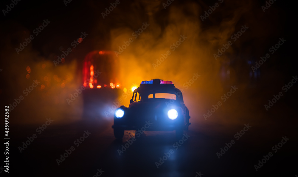 Police car chasing a car at night with fog background. 911 Emergency response police car speeding to scene of crime. Selective focus Police car chasing a car at night with fog background. 911 Emergency response police car speeding to scene of crime. Selective focus