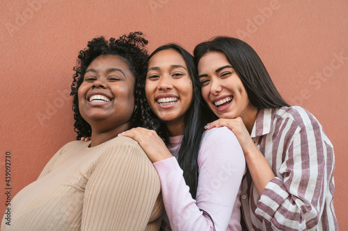 Happy multiracial friends having fun smiling together in front of camera photo