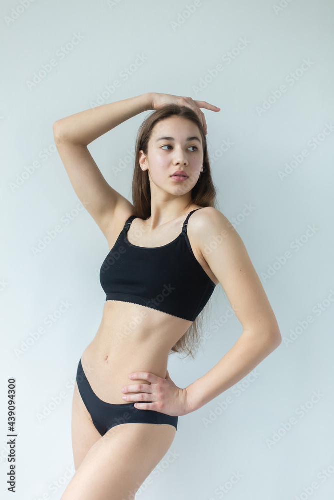 Natural beauty brunette model no make up in swimsuit posing in studio on isolated background. Model tests, natural no make up models concept Natural beauty brunette model no make up in swimsuit posing in studio on isolated background. Model tests, natural no make up models concept