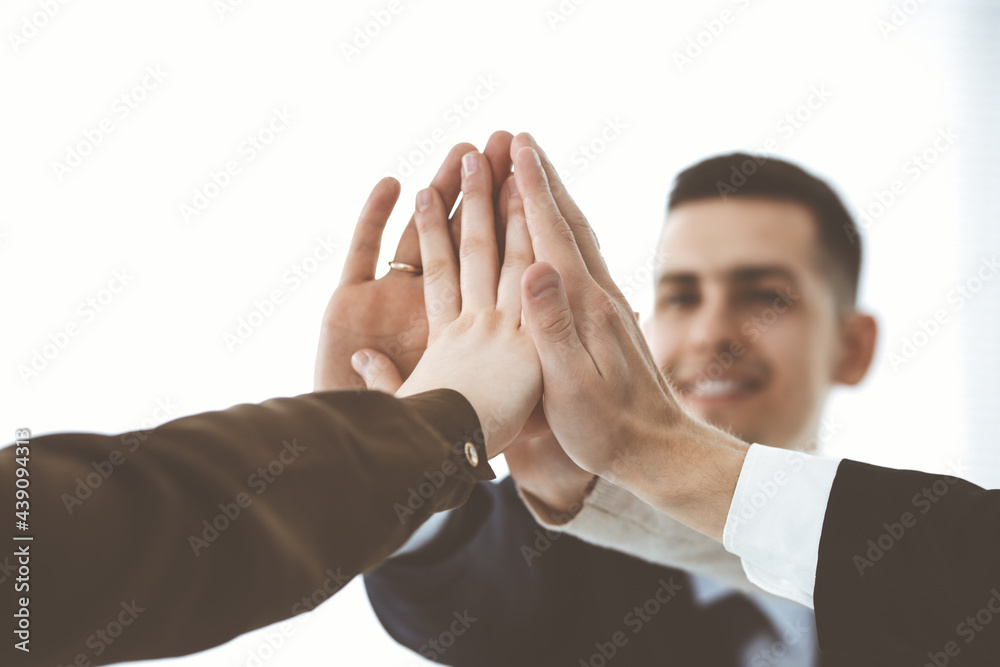 Business people group showing teamwork and joining hands or giving five in modern office. Unknown businessman and women making circle with their hands Business people group showing teamwork and joining hands or giving five in modern office. Unknown businessman and women making circle with their hands