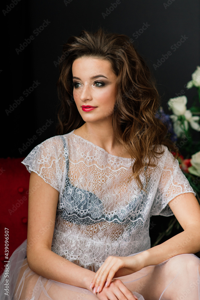 Fototapeta premium Bride in underwear and a white robe in the interior of hotel at a wedding.