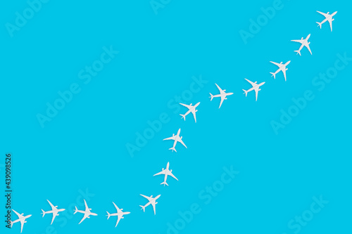 Simple traveling concept with toy airplanes on pastel blue background.