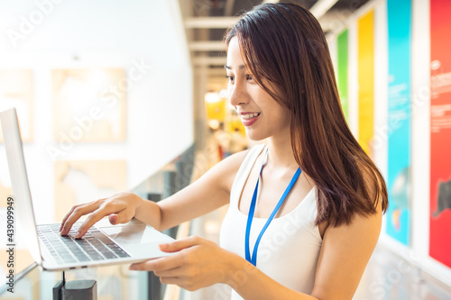 Portrait of Asian Woman Smiling Charmingly while Standing in walkway office. Portrait Of Successful Business Woman with laptop startup small business concept in modern office.