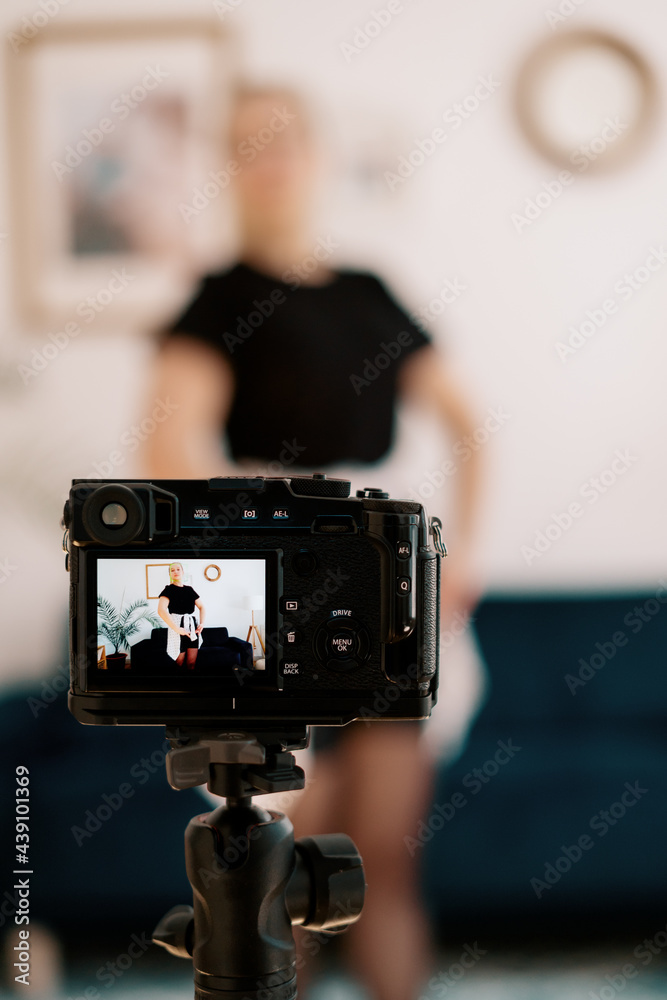 Online ballet classes, teacher explaining motion on camera screen. Young woman teaching ballet using a camera and tripod. Online ballet classes, teacher explaining motion on camera screen. Young woman teaching ballet using a camera and tripod.