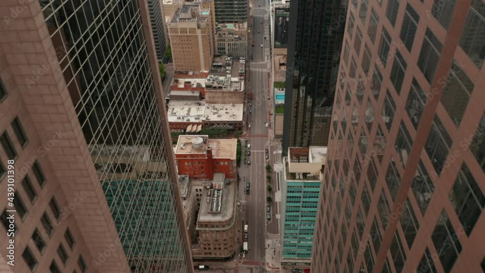 Aerial view of street downtown. Drone flying between tall office skyscrapers. Camera tilting down to Giant Eyeball sculpture in public park. Dallas, Texas, US Aerial view of street downtown. Drone flying between tall office skyscrapers. Camera tilting down to Giant Eyeball sculpture in public park. Dallas, Texas, US