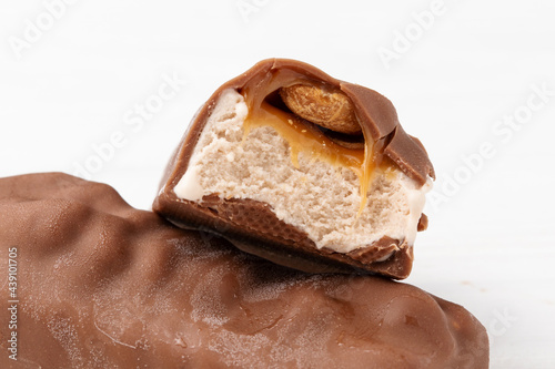 Fotografie Two chocolate ice cream bars with caramel and peanuts on white background close