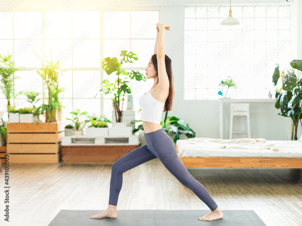 A young woman, wearing casual sports clothing, exercises at home every day, he does stretch exercises, yoga, fitness