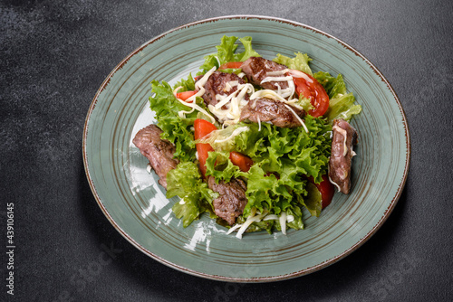 Delicious fresh salad with beef, cheese, tomatoes and lettuce leaves