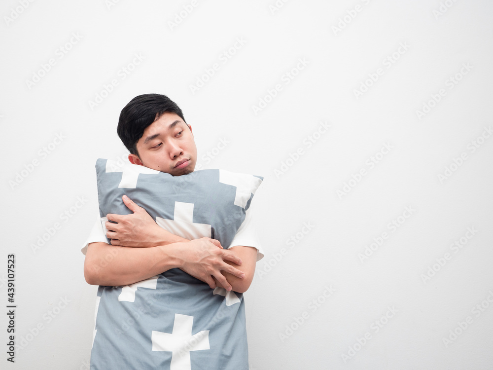 Asian man hug pillow feeling sleepy look at space white background Asian man hug pillow feeling sleepy look at space white background