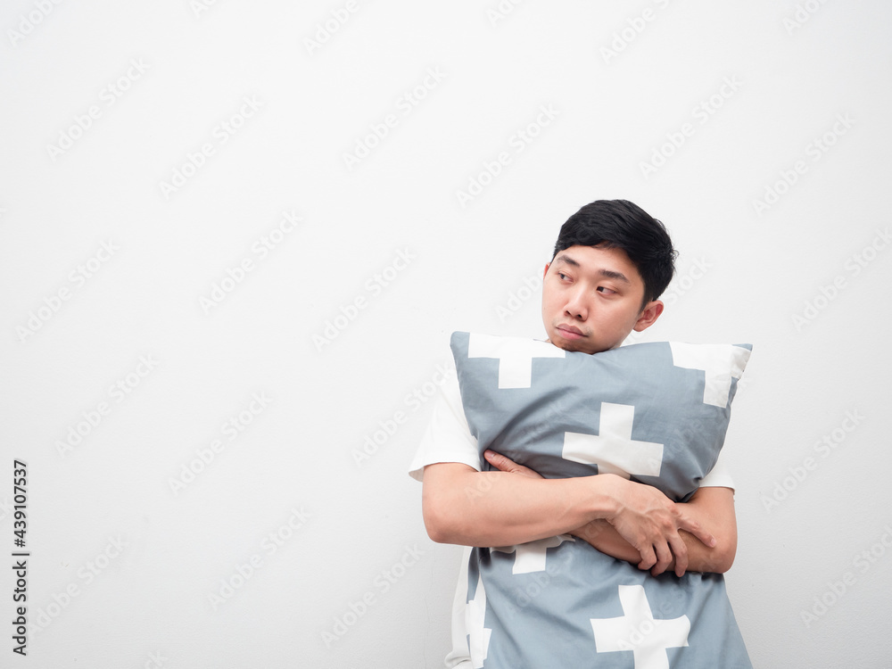 Asian man hug pillow feeling sleepy look at space white background Asian man hug pillow feeling sleepy look at space white background