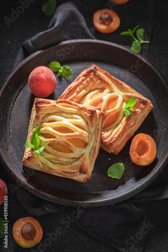 Homemade puff pastry baked with peaches. French juicy dessert.