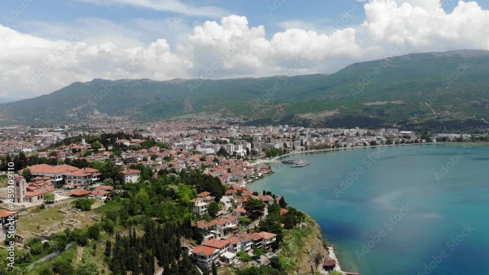 Drone view of the resort town of Ohrid. Drone shot overlooking Lake Ohrid and a small town against the backdrop of green mountains. A pier with boats in the center of Ohrid, a view from above. Drone view of the resort town of Ohrid. Drone shot overlooking Lake Ohrid and a small town against the backdrop of green mountains. A pier with boats in the center of Ohrid, a view from above.