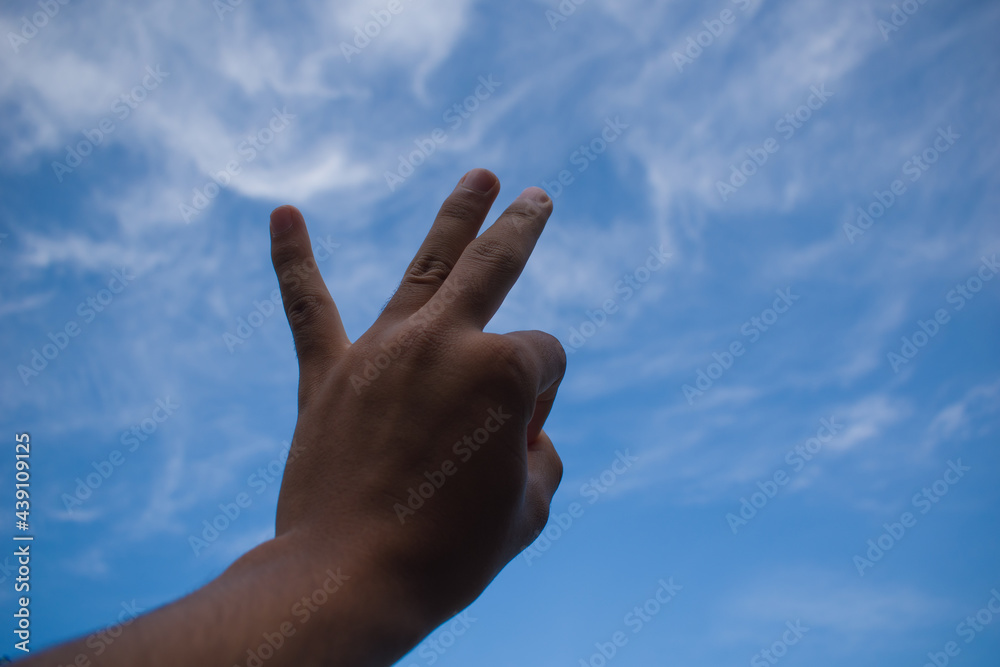 Ok gesture with left hand to dark blue sky Ok gesture with left hand to dark blue sky