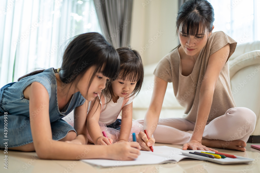 Parent mom and siblings girl have fun draw and color picture on floor Parent mom and siblings girl have fun draw and color picture on floor