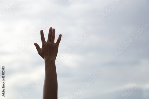 Silhouette of Christian prayers raising hand while praying to the god