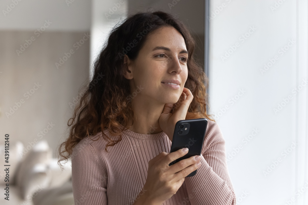 Pensive millennial Latin woman use cellphone look in distance thinking pondering or dreaming or perspectives. Thoughtful young Hispanic female hold smartphone. Technology, communication concept. Pensive millennial Latin woman use cellphone look in distance thinking pondering or dreaming or perspectives. Thoughtful young Hispanic female hold smartphone. Technology, communication concept.