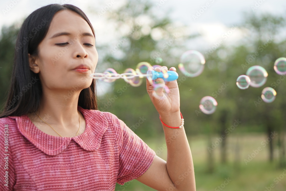 Asian woman blowing soap bubbles every green grass background Asian woman blowing soap bubbles every green grass background