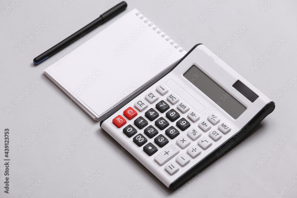 Calculator and notebook on gray background. Top view. Flat lay Calculator and notebook on gray background. Top view. Flat lay