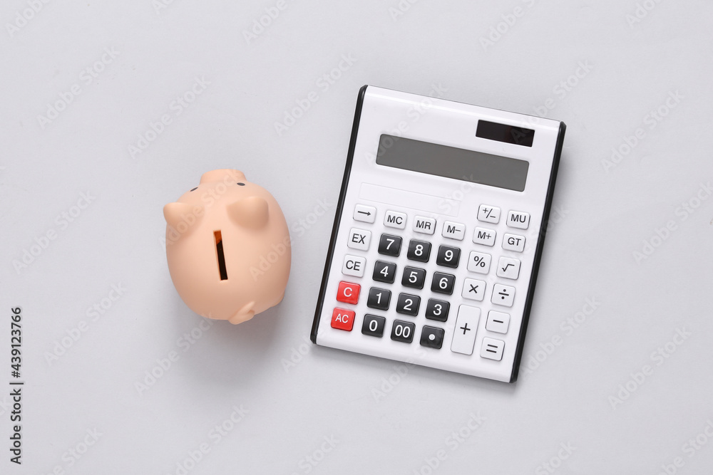 Calculator with piggy bank on gray background. Calculator with piggy bank on gray background.