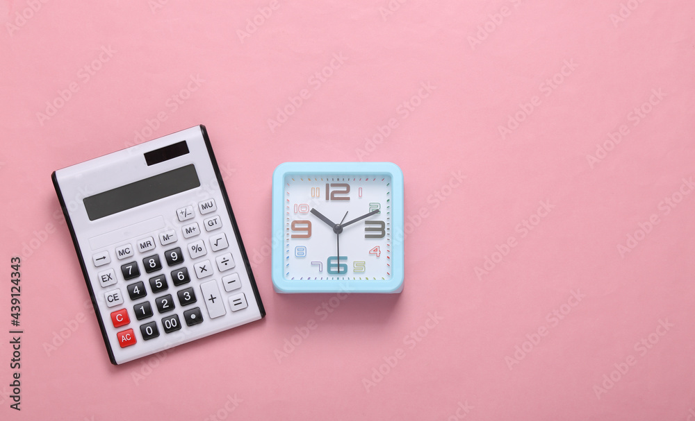 Calculator and alarm clock on a pink background. Top view Calculator and alarm clock on a pink background. Top view
