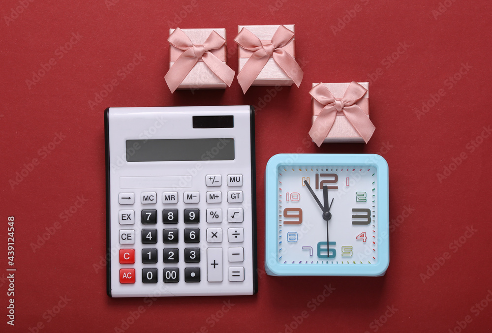 Gift boxes and alarm clock calculator on red background. Top view Gift boxes and alarm clock calculator on red background. Top view