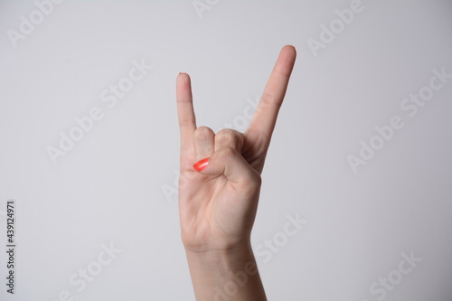 Woman hand showing devil horns gesture. Winning and triumph sign isolated on white background.