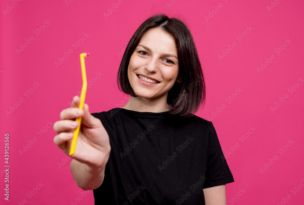 Beautiful happy young woman with single tufted toothbrush on blank pink background Beautiful happy young woman with single tufted toothbrush on blank pink background