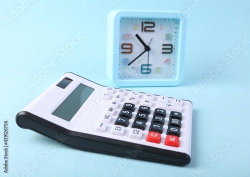 Alarm clock and calculator on blue background