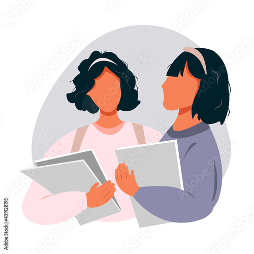 Two female students standing together and talking, education and youth concept
