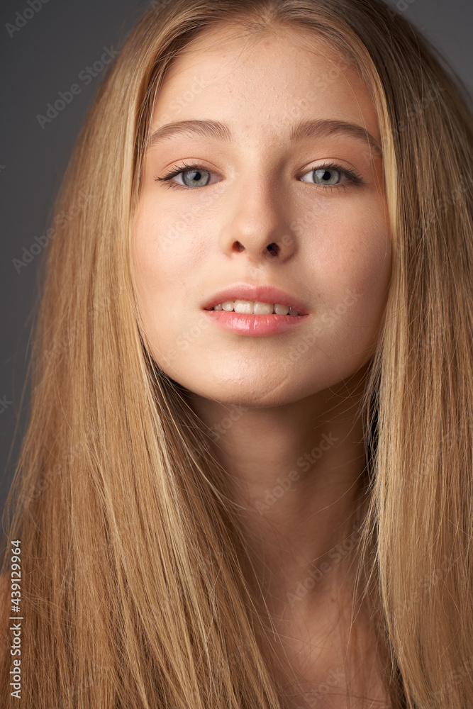 Natural portrait of young beautiful teen age girl with long straight hair. Female model studio shot against grey background. Pretty girl Natural portrait of young beautiful teen age girl with long straight hair. Female model studio shot against grey background. Pretty girl