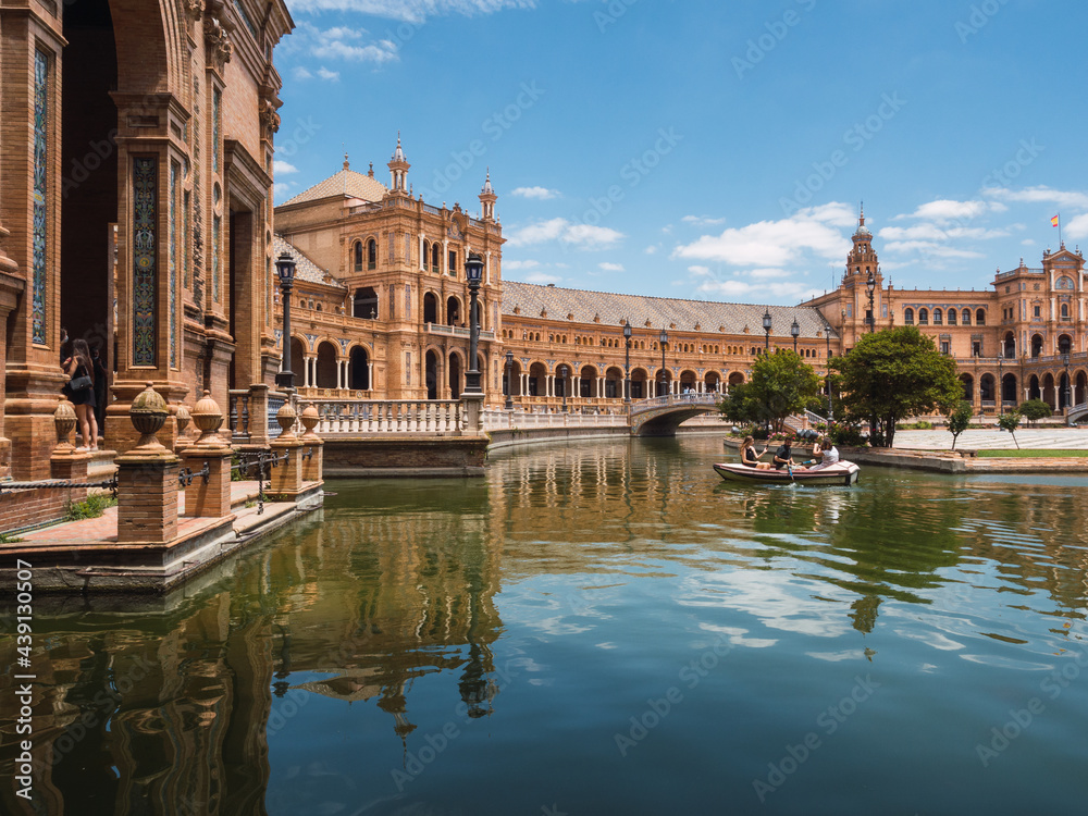 Tourists sail in a boat next to Plaza España in Seville.