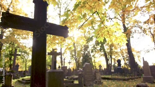Gravestones with crosses at the Bernardine XIX century cemetery in the sunny Autumn day. Filmed against the sun in slow motion. Vilnius, Lithuania photo