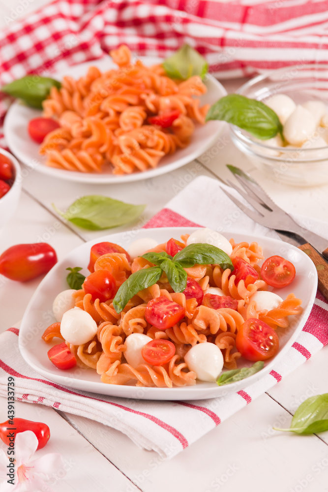 Fusilli pasta with cherry tomatoes and mozzarella cheese.