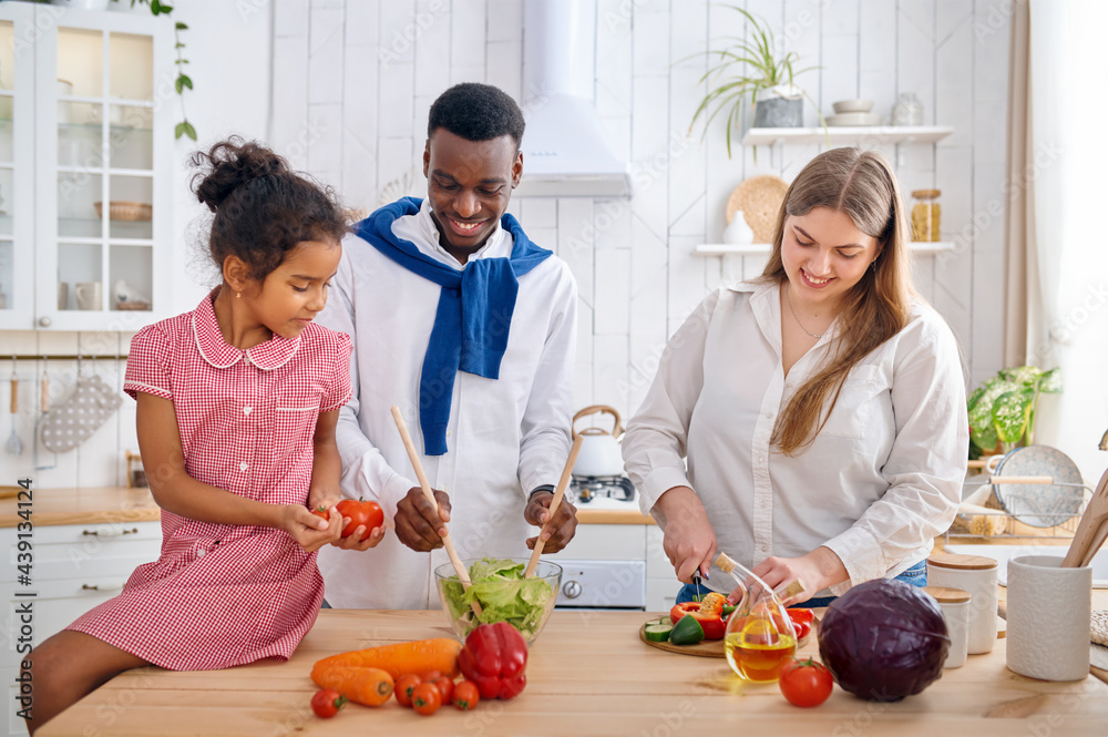 Cheerful family cooking salad on breakfast Cheerful family cooking salad on breakfast