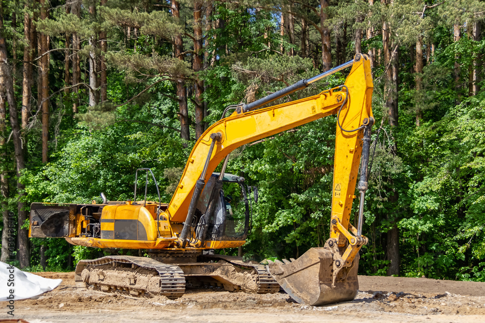 The excavator prepares the site for the construction of the road The excavator prepares the site for the construction of the road
