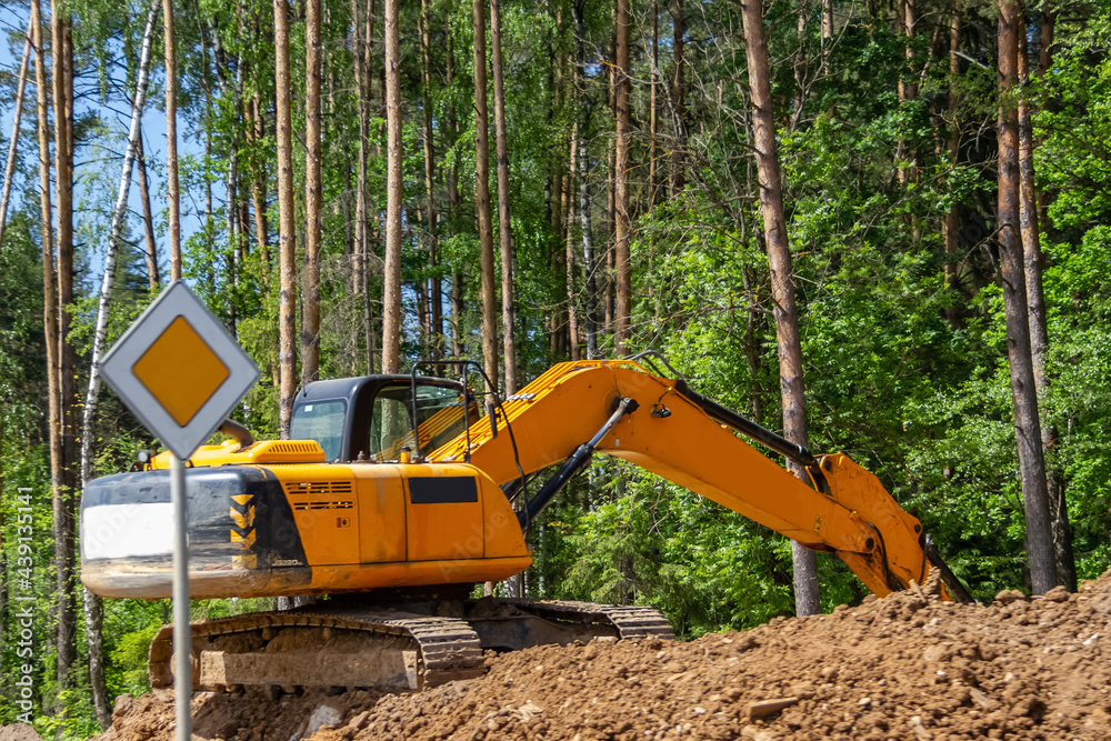 The excavator prepares the site for the construction of the road The excavator prepares the site for the construction of the road